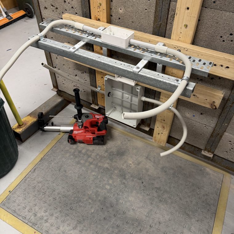 Cable tray and corrugated conduit run into junction boxes on a training wall